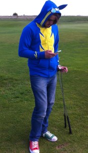 A brony in a hoody with ears and a smart phone on a golf course